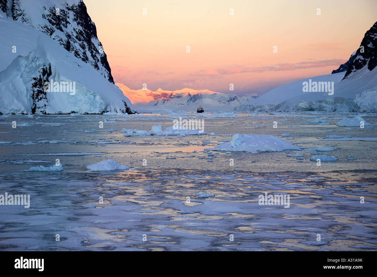 Soleil de minuit couleurs rose les sommets des montagnes à 2h00 dans le canal de Lamairé sur la péninsule Antarctique dans l'Antarctique Banque D'Images