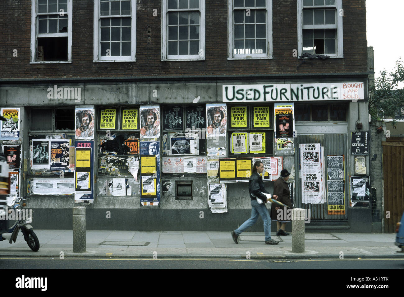 Quartier délabré de Londres avec des affiches et des graffitis jonchant les murs des bâtiments Banque D'Images