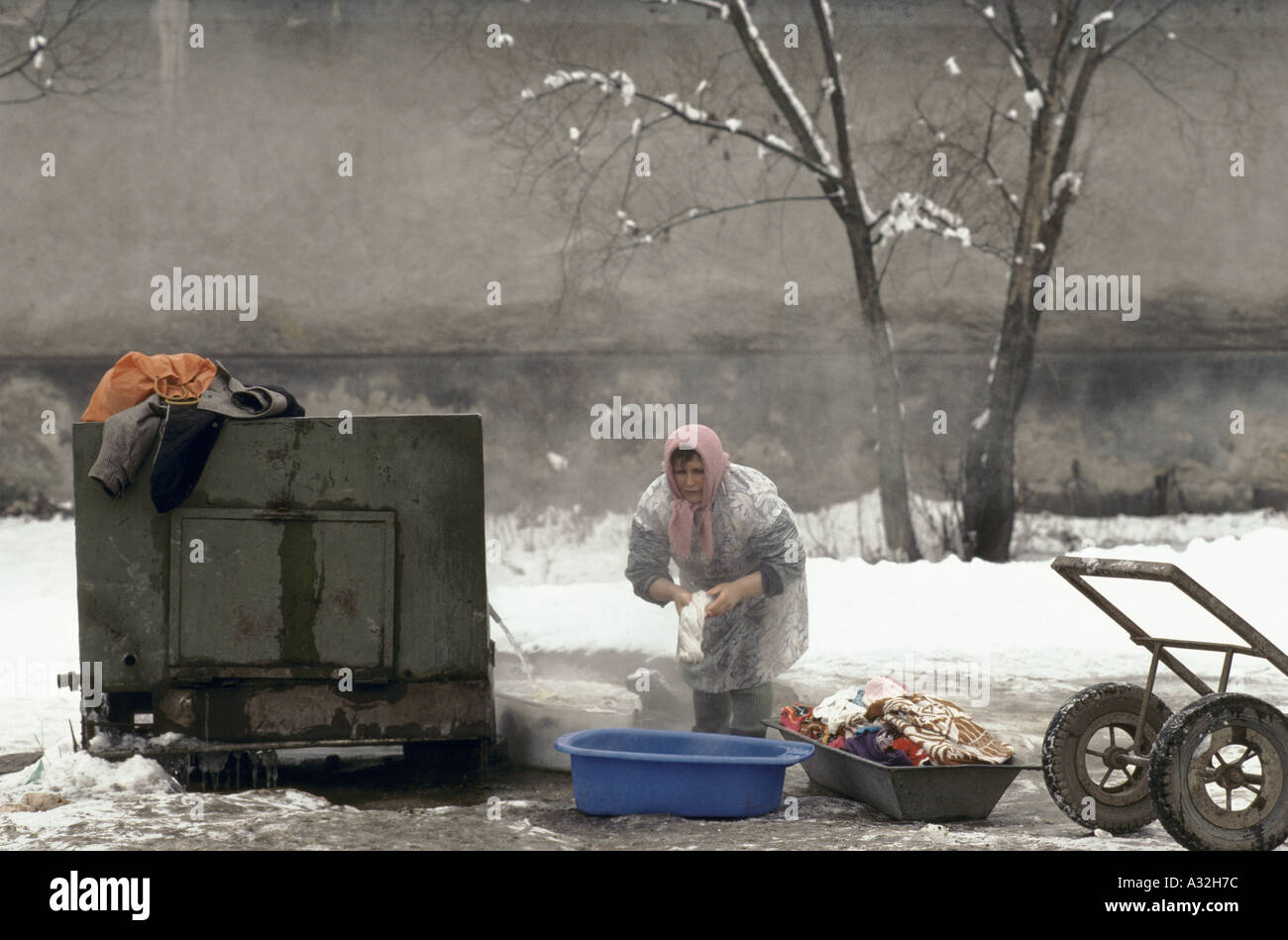 La Roumanie après la révolution femme lave des vêtements de plein air au réservoir d'eau en hiver la Transylvanie 1990 Banque D'Images