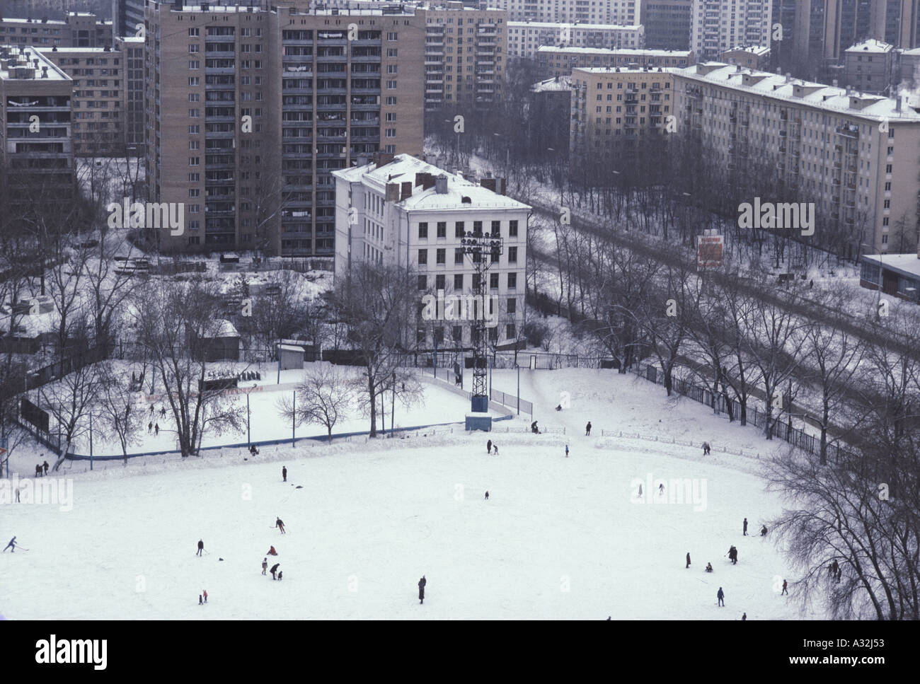 Moscou Saint-Pétersbourg blocs haute vue de l'appartement à côté du parc public où les gens sont le patinage pratiquer le hockey sur glace sur la patinoire de plein air de marcher dans la neige banlieue de Moscou 1983 Banque D'Images