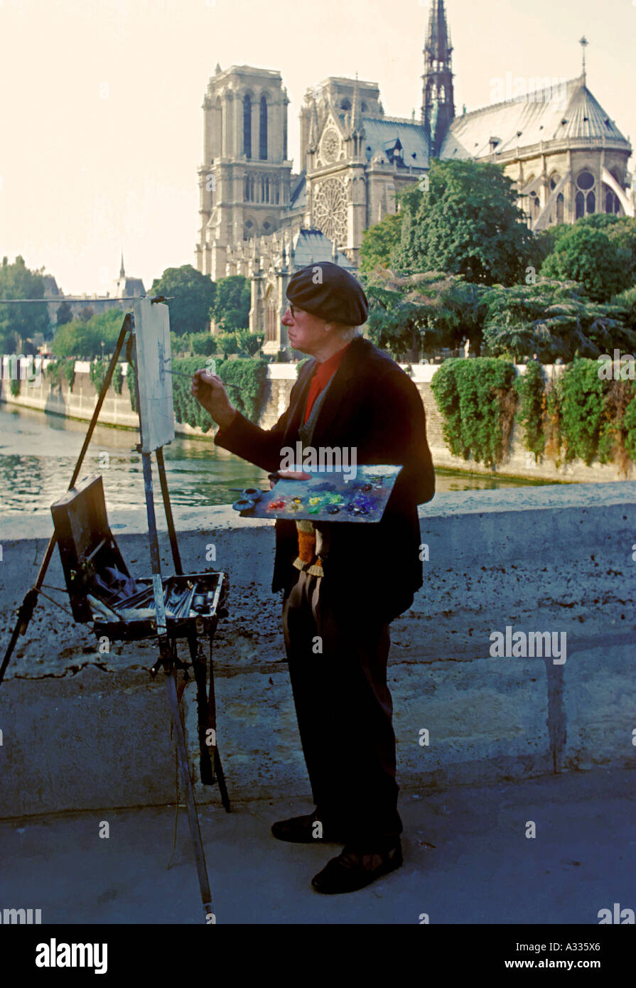 Un vieil artiste fait un plein air Piscine peinture de la Cathédrale Notre Dame de Paris France Banque D'Images