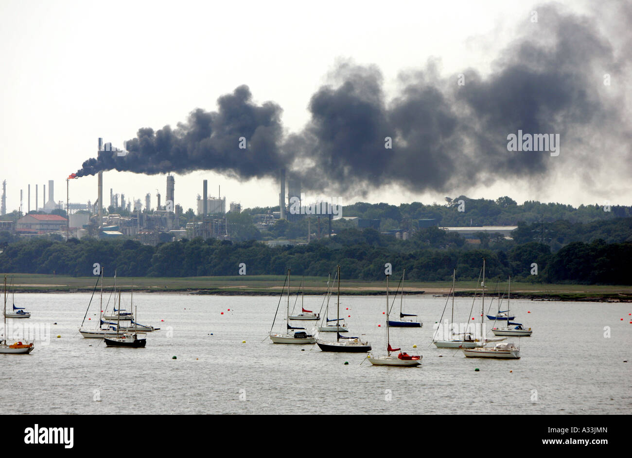 Raffinerie de pétrole de fawley fumeurs fumée noire dans la région près de Southampton à la recherche sur le Solent Banque D'Images