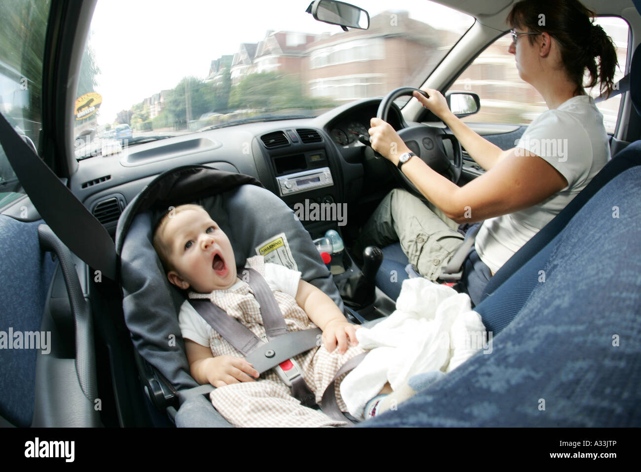La mère et l'enfant la conduite en voiture avec bébé en porte-bébé siège  avant Photo Stock - Alamy