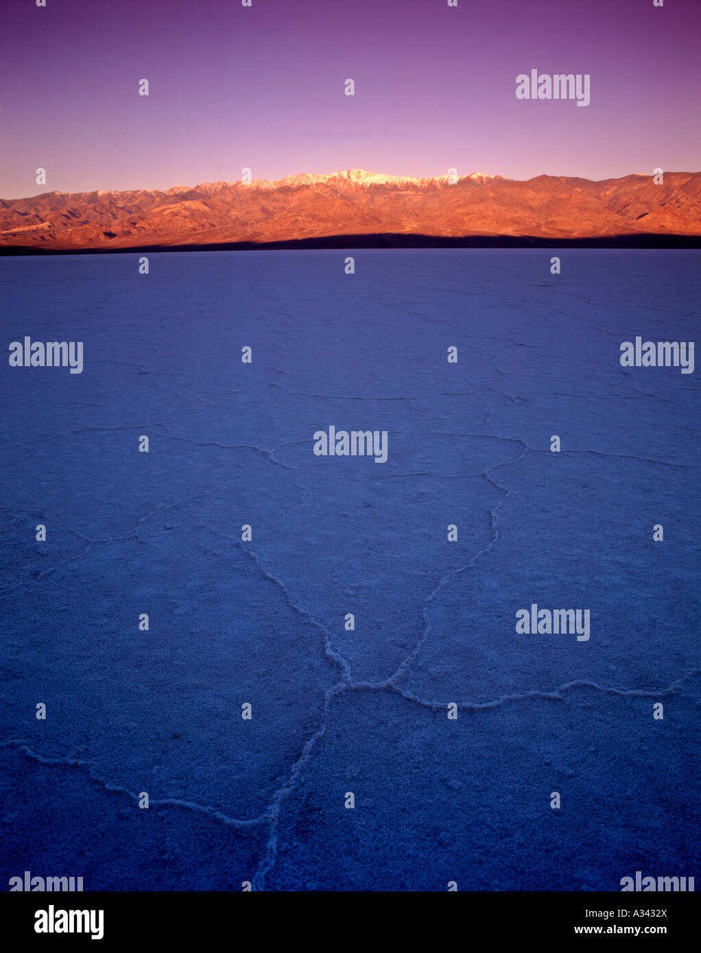 Lever du soleil réchauffe la lumière et le pic de télescope Panamint Range, du sel casserole de Badwater, Death Valley National Park, Californie Banque D'Images