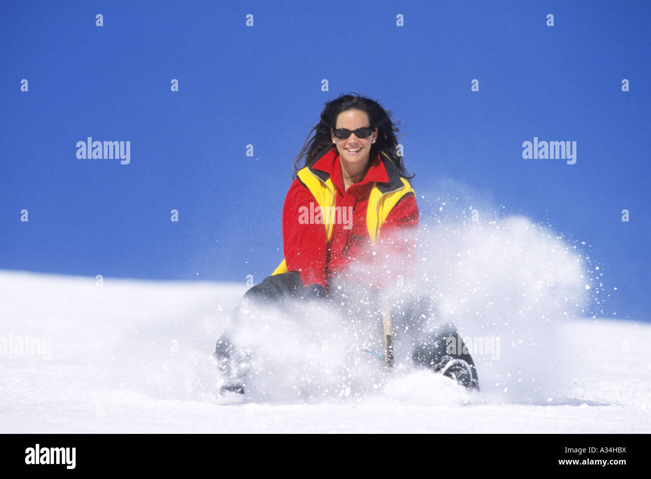 Femme taboggoning, Autriche, Alpes Banque D'Images