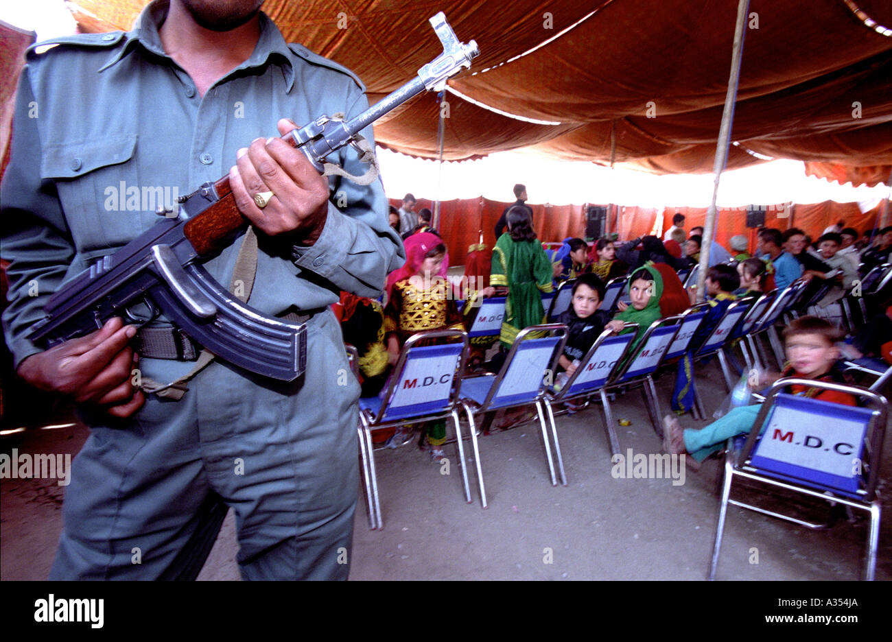 Un agent de sécurité afghanes s'occupe des enfants qui sont enjoing un spectacle organisé par SOA. Banque D'Images