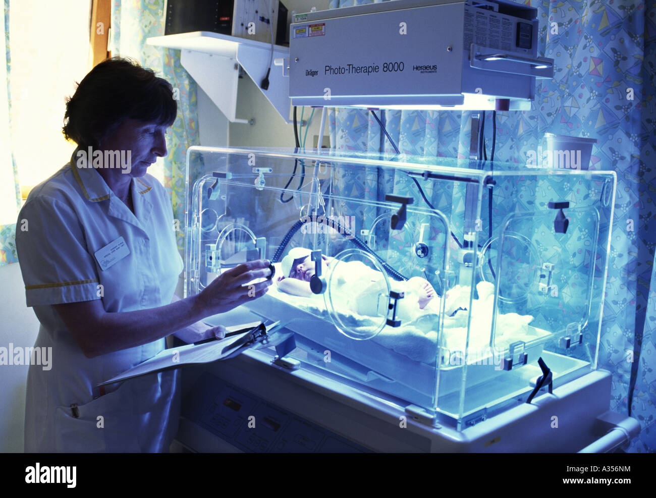 Infirmière pédiatrique surveille bébé avec jaunisse traités par la photothérapie dans un incubateur Banque D'Images