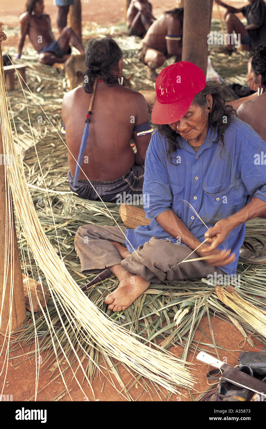 Un Ukre Village indien Kayapo du Brésil dans un bouchon rouge, faire un cordon pour un panier de fibres de feuilles de palmier de la réserve autochtone de Xingu Banque D'Images