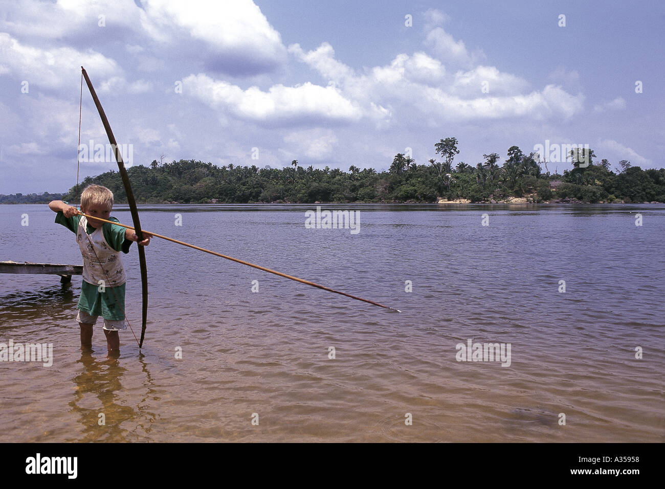 Tataquara Amazon Brésil garçon de pêche dans la rivière Xingu avec arc et flèche longue Banque D'Images