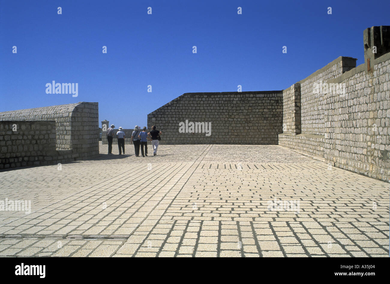 Les touristes dans la distance à la découverte de la ville en pierre du xiiie siècle autour des murs de parapet Dubrovnik Croatie Dalmatie du sud Banque D'Images