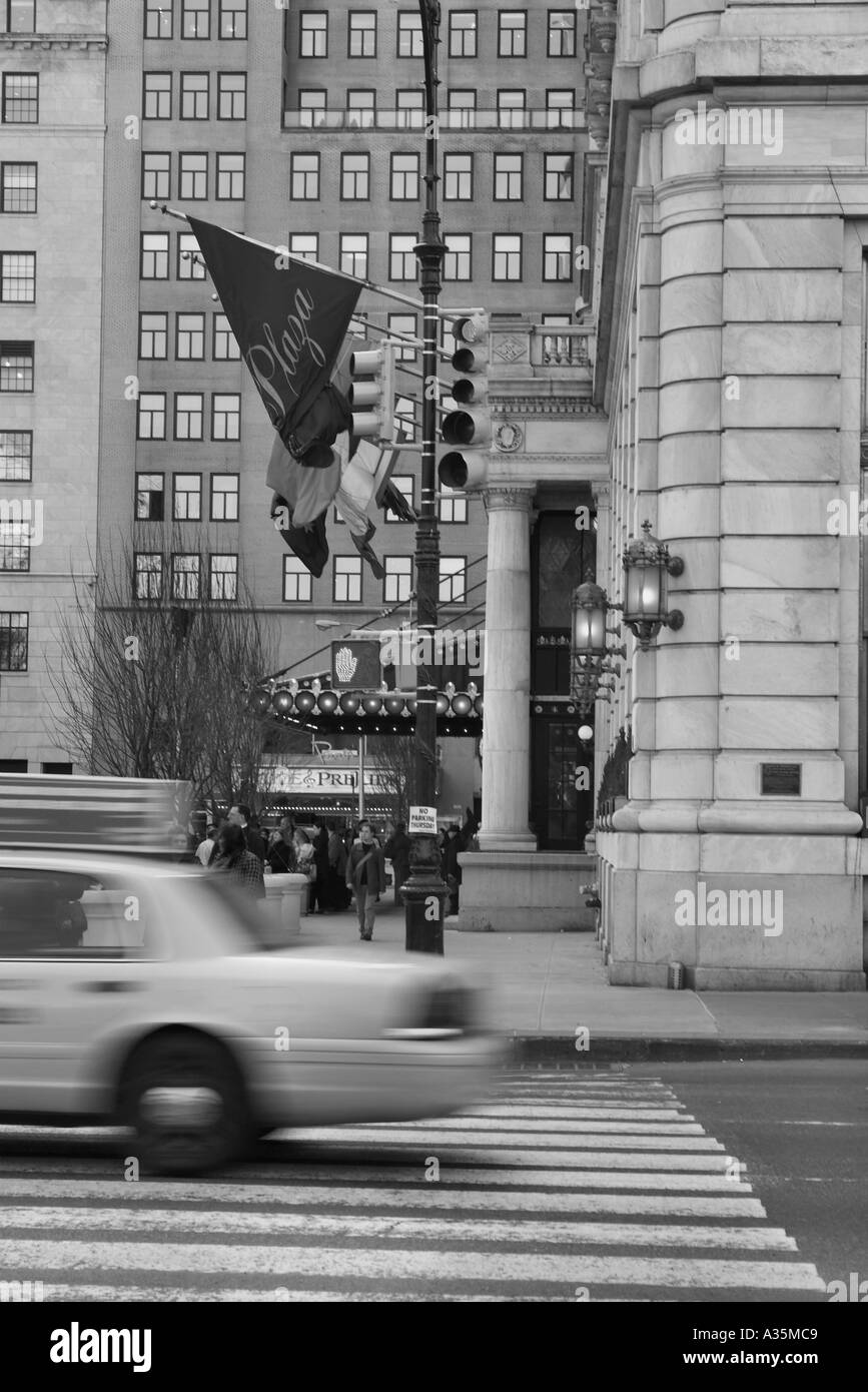 Un taxi par la vitesse Plaza Hotel à New York City USA Photo rendu comme le noir et blanc Banque D'Images