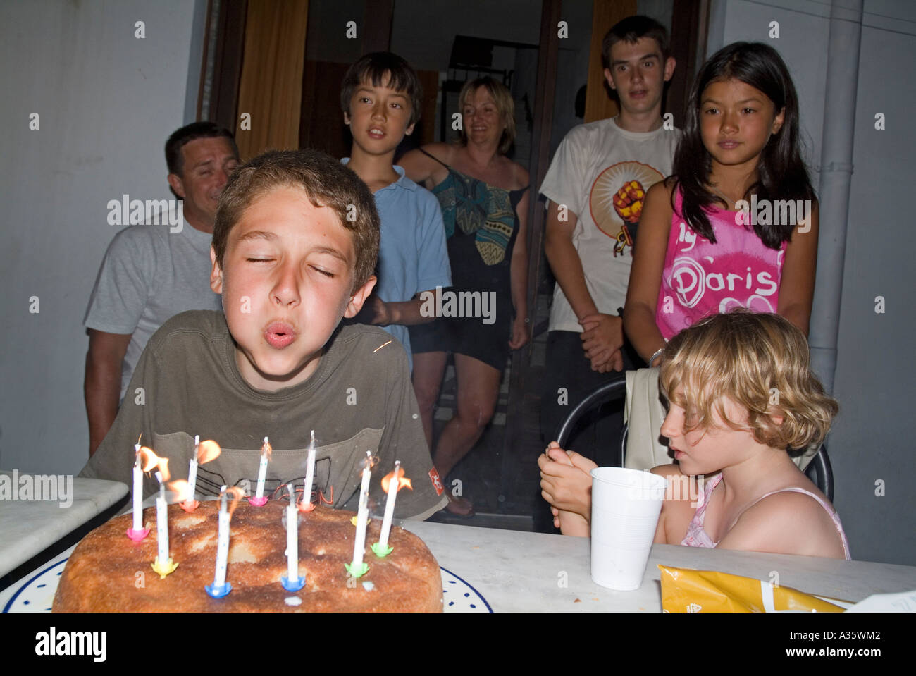 Boy blowing out candles sur son gâteau d'anniversaire. Banque D'Images