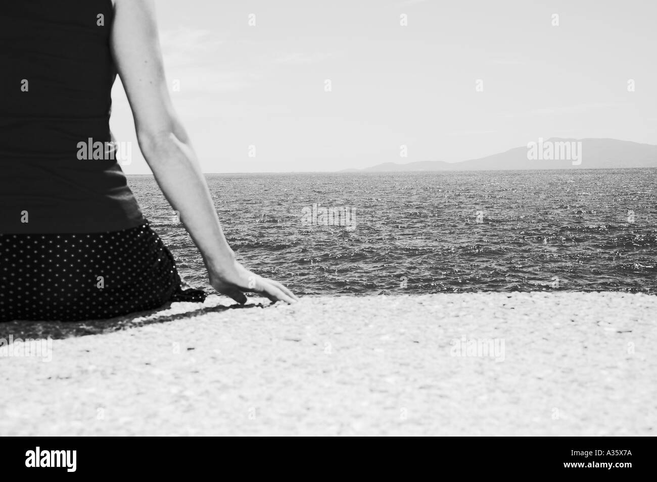 Femme assise en mer Banque D'Images