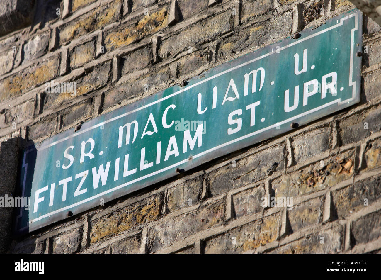 Vert et blanc style ancien fitzwilliam street upper signer en irlandais et en anglais à Dublin le mur de brique rouge Banque D'Images