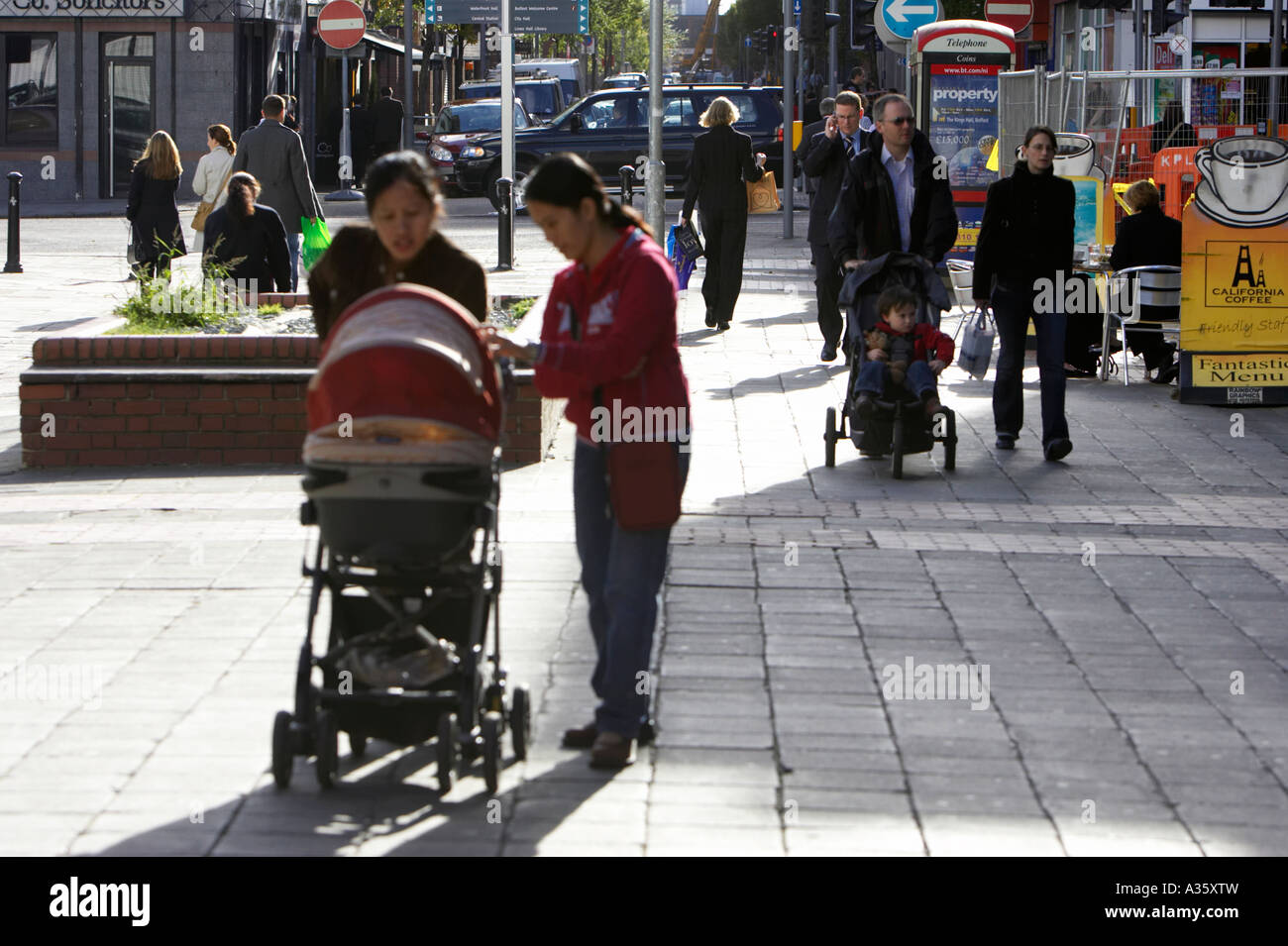 Les gens poussant poussettes Landaus en zone piétonnière de Belfast City Centre Banque D'Images