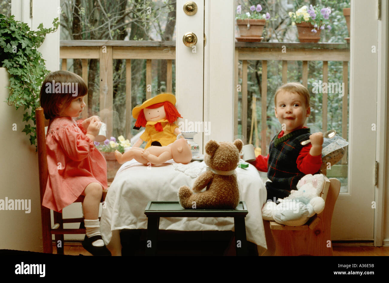 Une jeune fille et garçon sont habillés et avoir un thé avec leurs animaux en peluche Banque D'Images