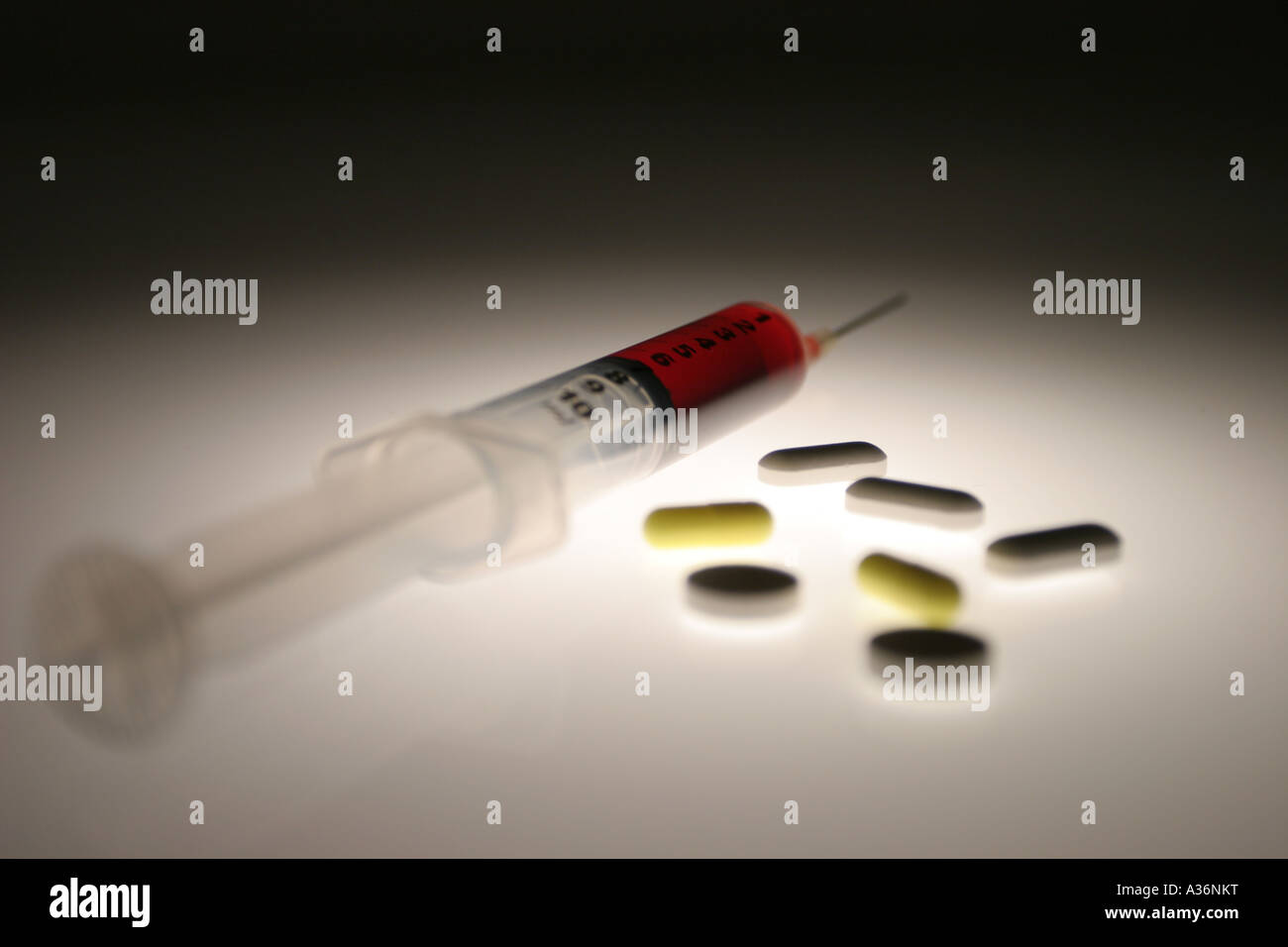 Seringue pleine de sang à côté de collection de comprimés Banque D'Images