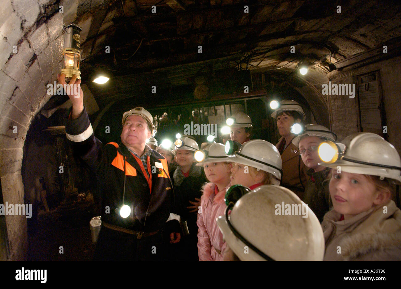 Un guide ancien mineur d'élèves donnant une visite souterraine à Big Pit National Coal Museum Blaenavon South Wales UK Banque D'Images