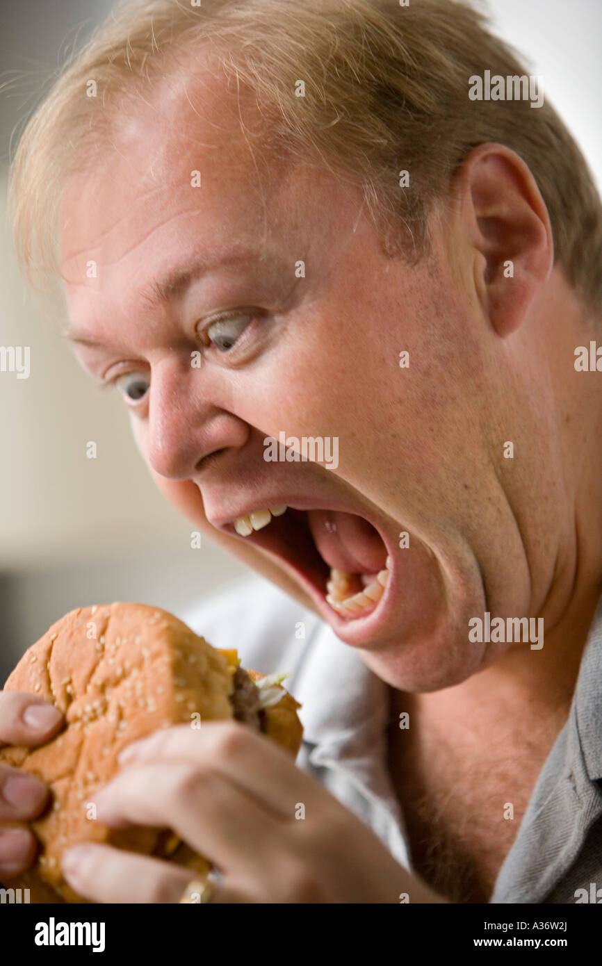 Image d'humour d'un homme sur le point de mordre dans un hamburger Banque D'Images