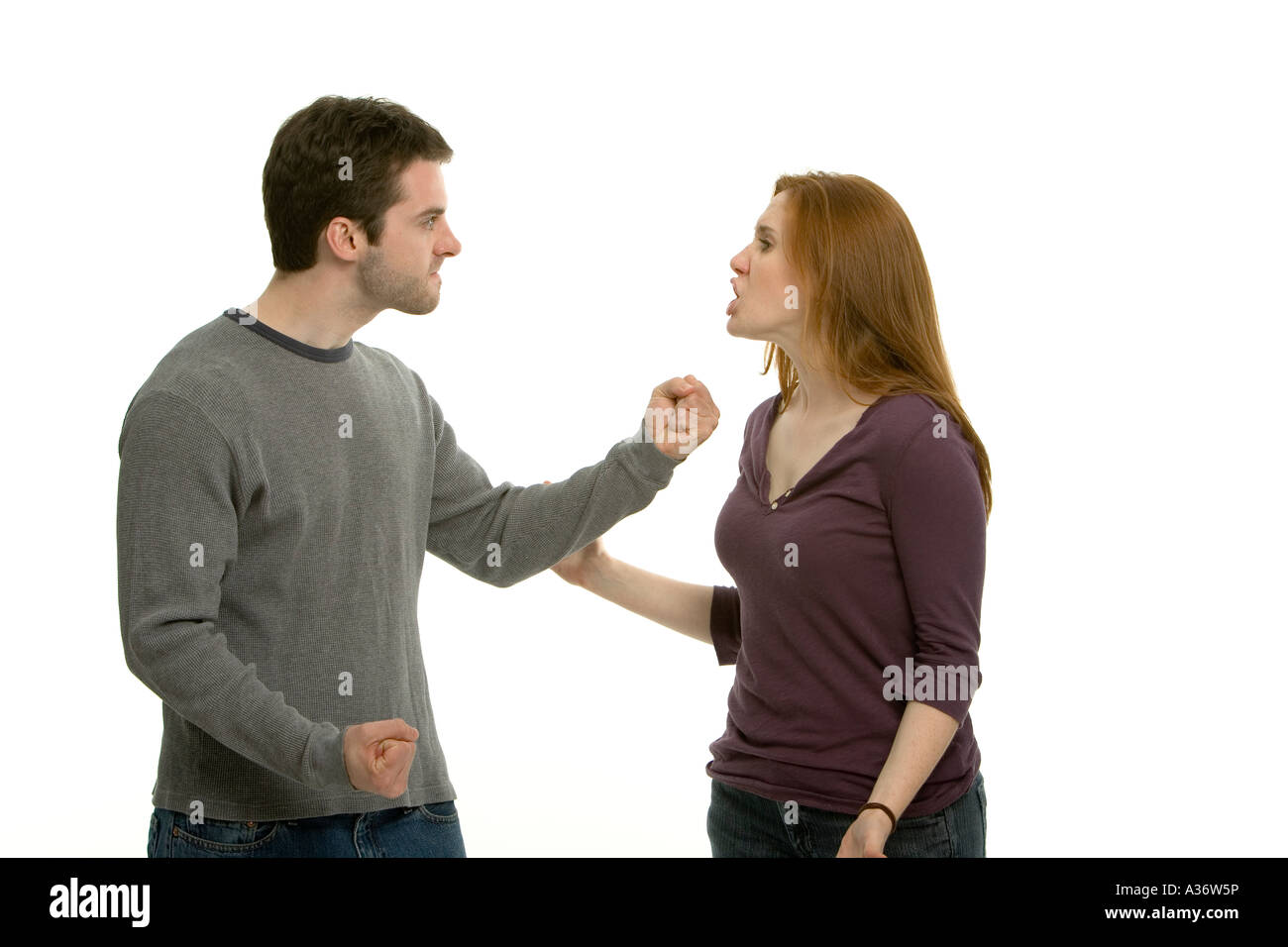 Young couple having an argument. Elle est criant et il a l'air furieux avec les poings serrés. Banque D'Images
