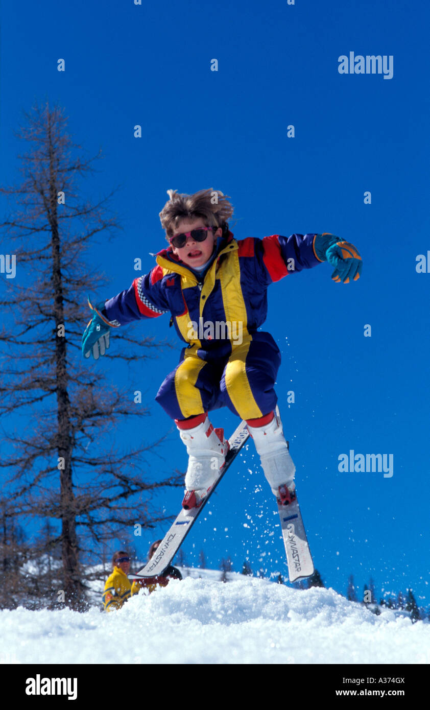 Jeune garçon essayant petit ski jump sur un monticule de neige Banque D'Images