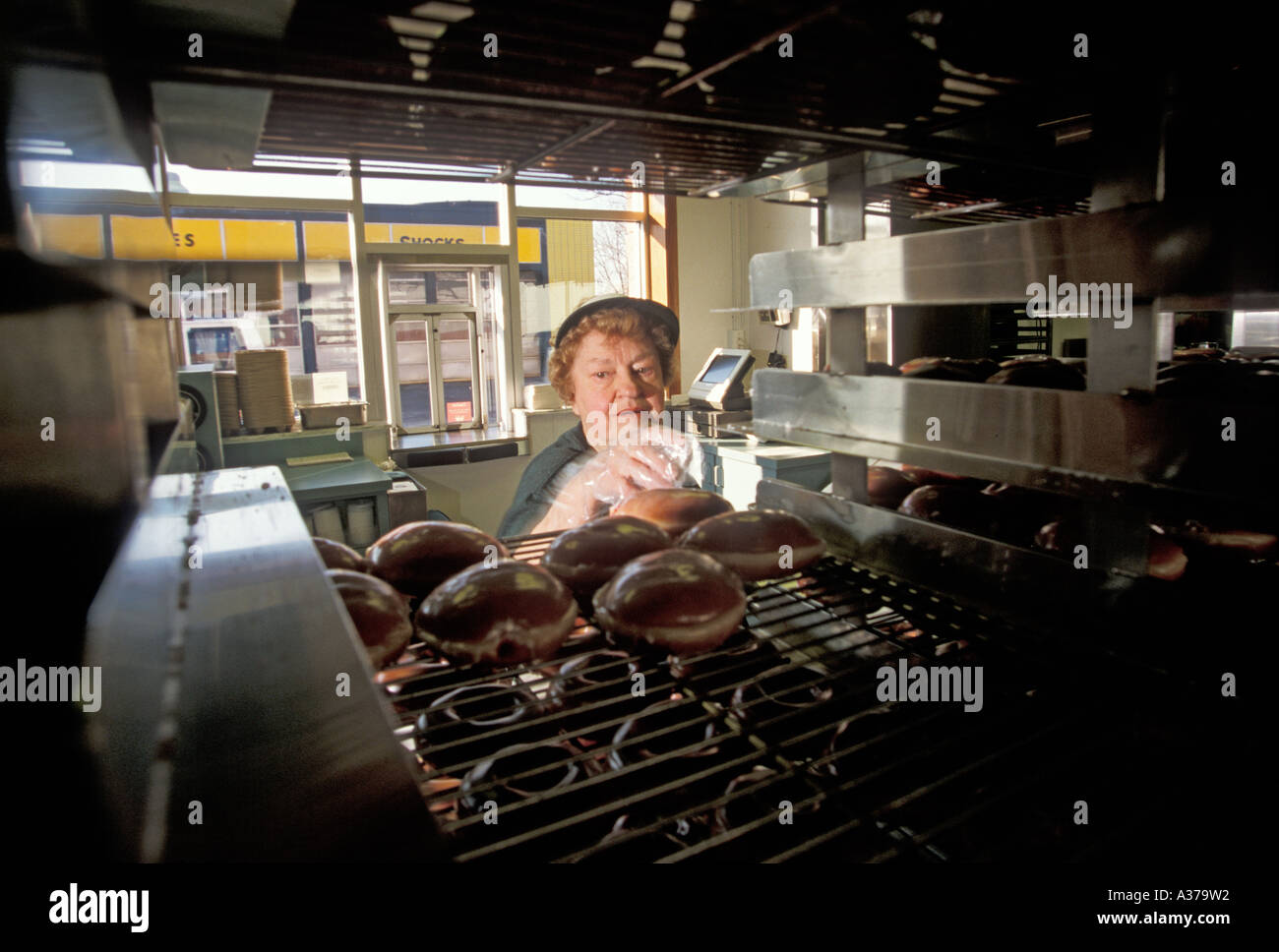 Warren Michigan Virginie Gaer 77 picks donuts off bacs pour un client au Krispy Kreme doughnut shop Banque D'Images