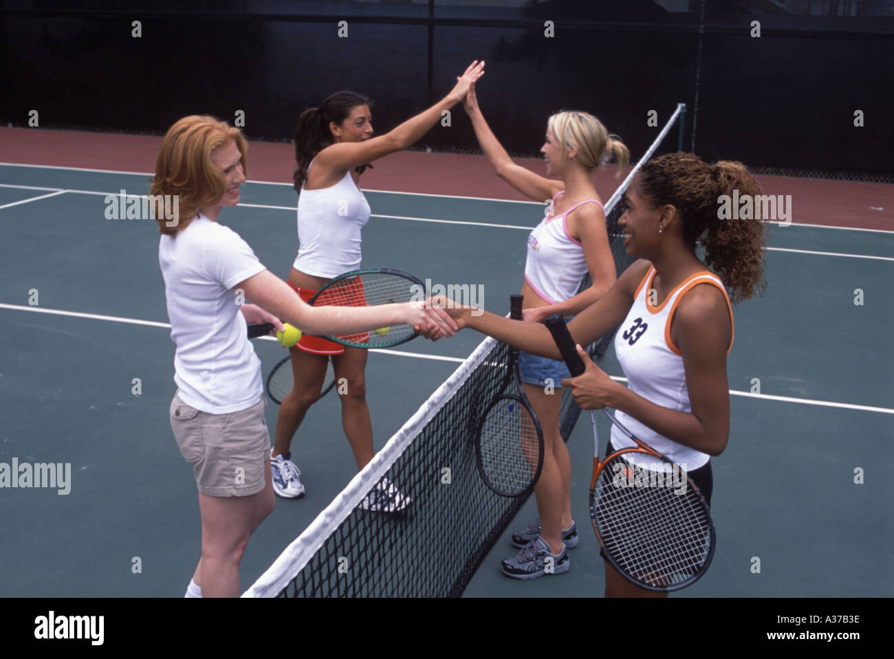 Les femmes ethniquement mixte jouant au tennis Caucasian Latina Hispanic et Afro-américain Banque D'Images