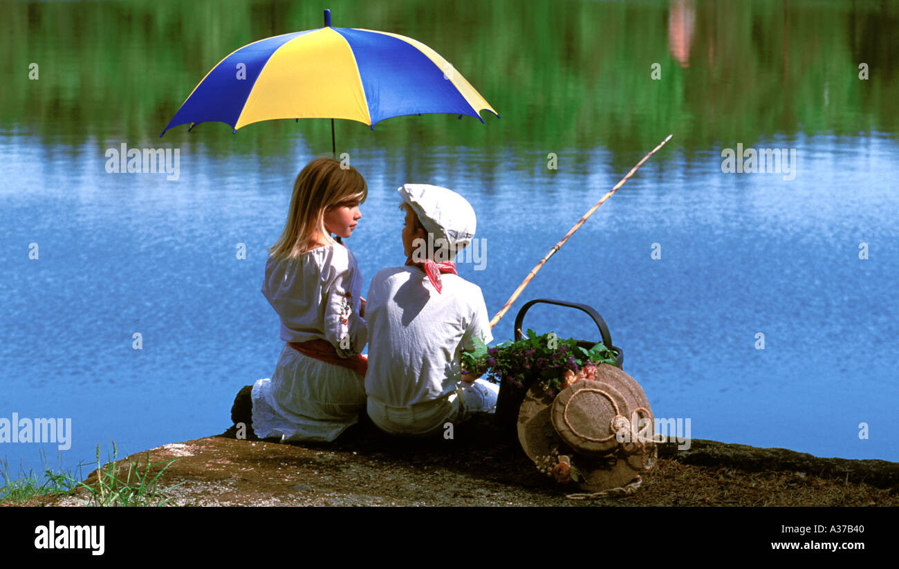 Deux enfants de 5 à 10 ans sur la pêche pique-nique avec les couleurs nationales suédoises sur umbrella Banque D'Images