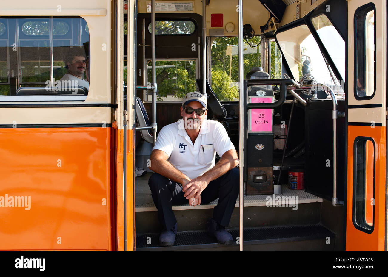 Kenosha WISCONSIN conducteur tramway restauré wearing baseball cap s'asseoir sur les marches du wagon passager Banque D'Images