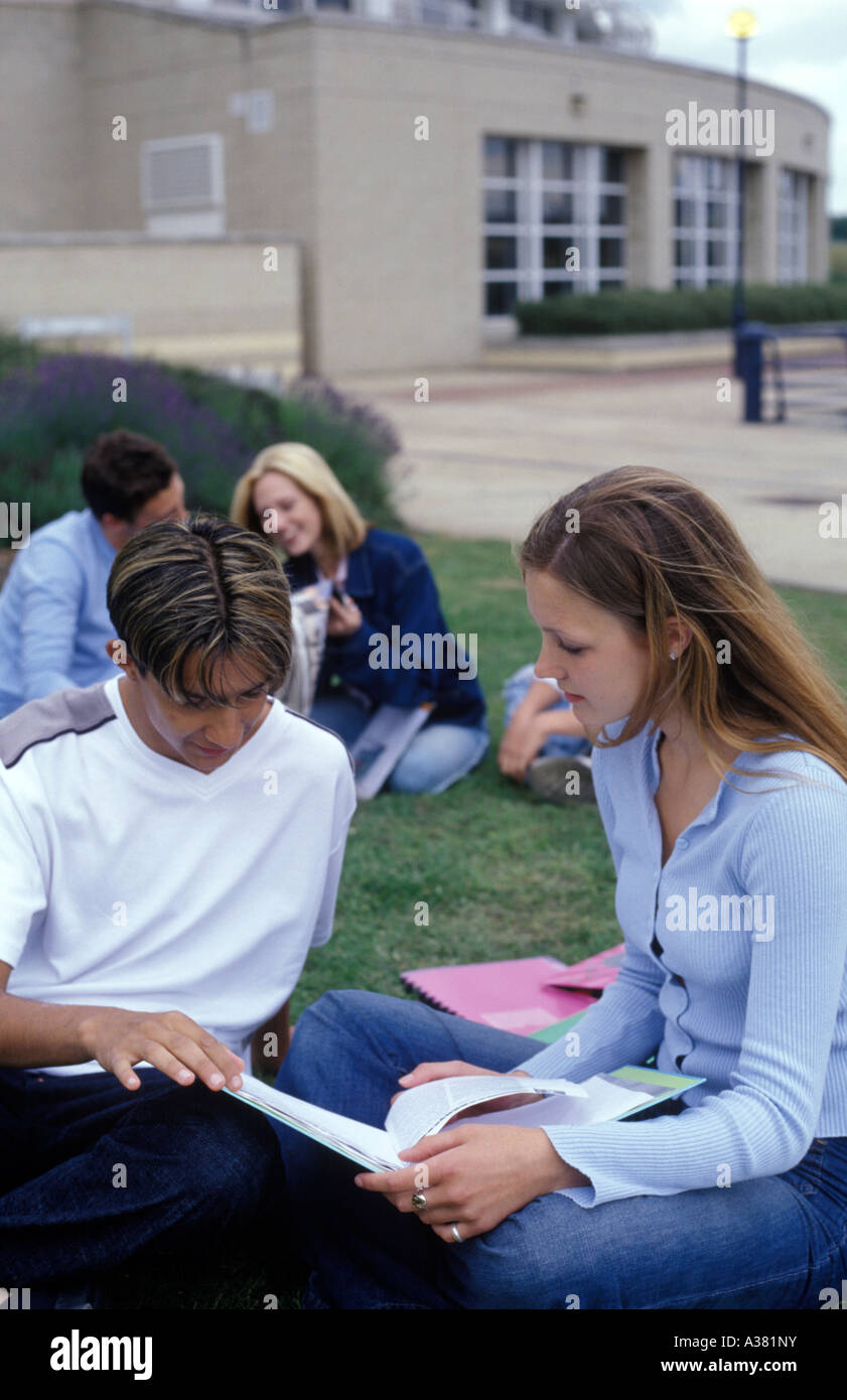 Les adolescents assis à l'extérieur du bâtiment de l'université Banque D'Images