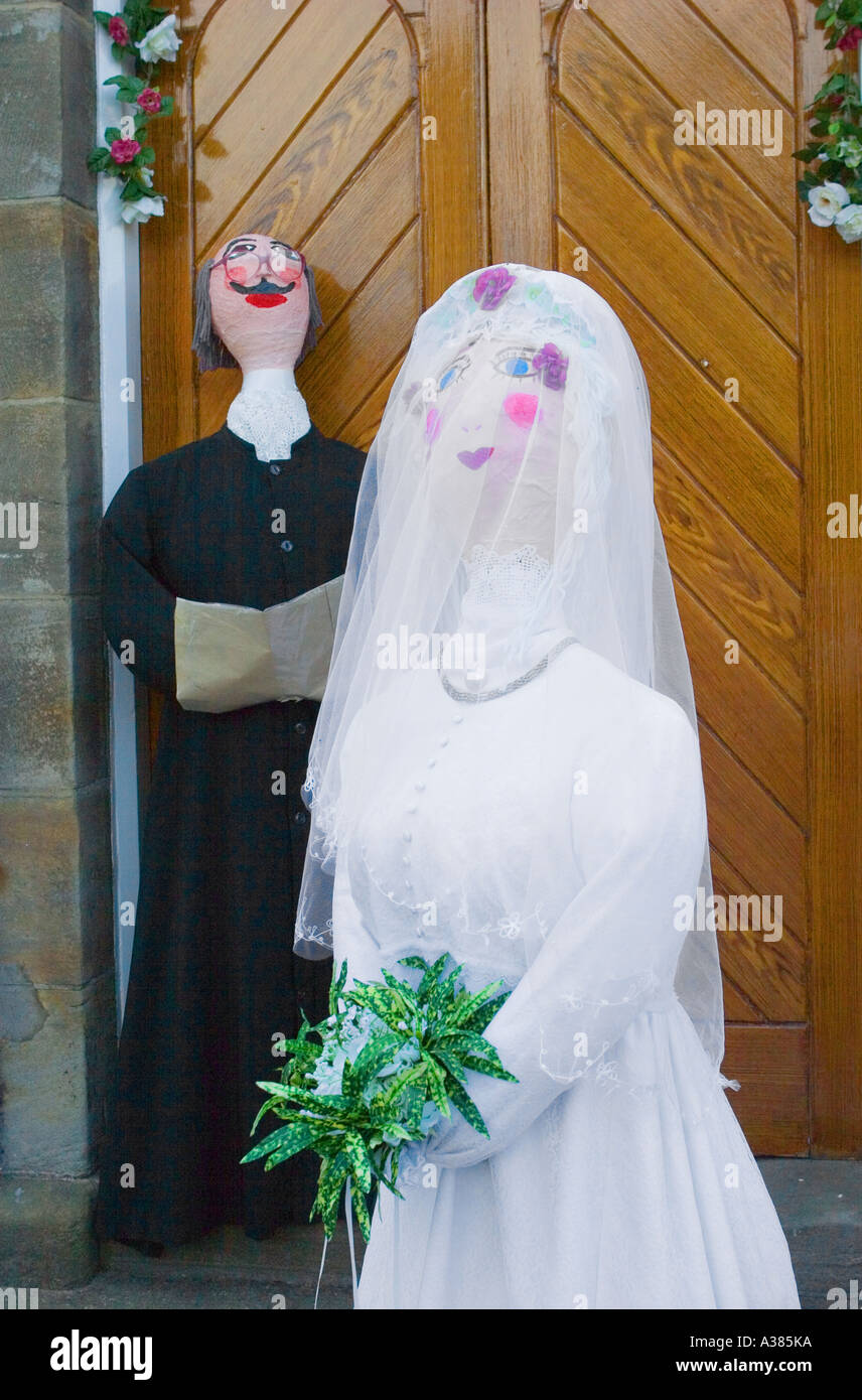 Le papier mâché personnages religieux ; les mariés à l'église d'attente Hinderwell festival. Banque D'Images