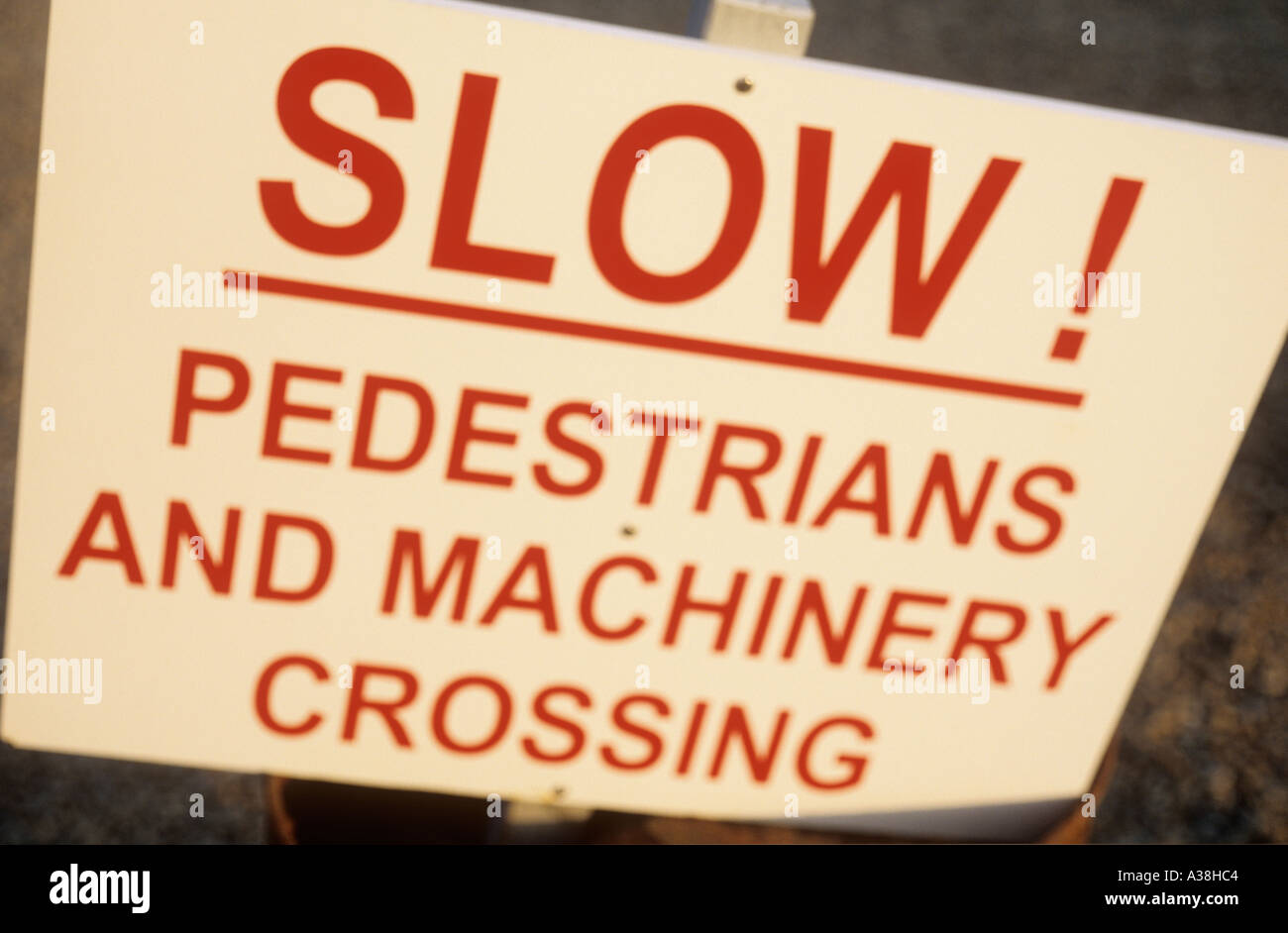 Signe de flou artistique peint en blanc avec les lettres en rouge les conducteurs d'avertissement de passage piétons lents et machines Banque D'Images