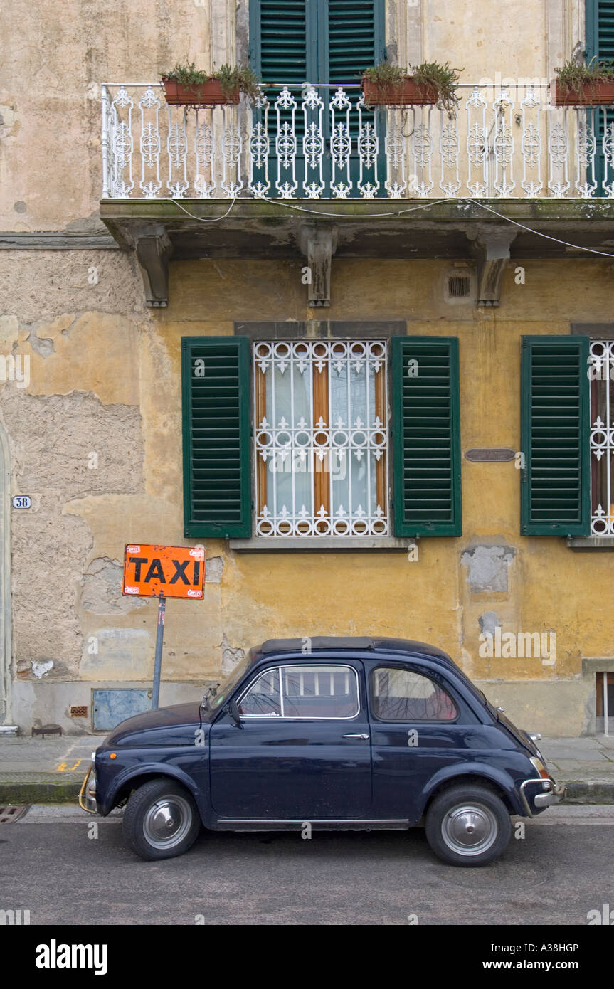 Un vieux classique Fiat 500 bleu foncé garé sur la route ironiquement à côté d'un 'TAXI'. Banque D'Images