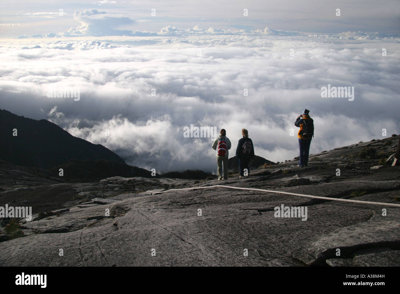 Les randonneurs regarder les nuages en rouleau sur la descente du Mont Kinabalu, à 3867 m le plus haut en Asie. Sabah, Bornéo, Malaisie Banque D'Images