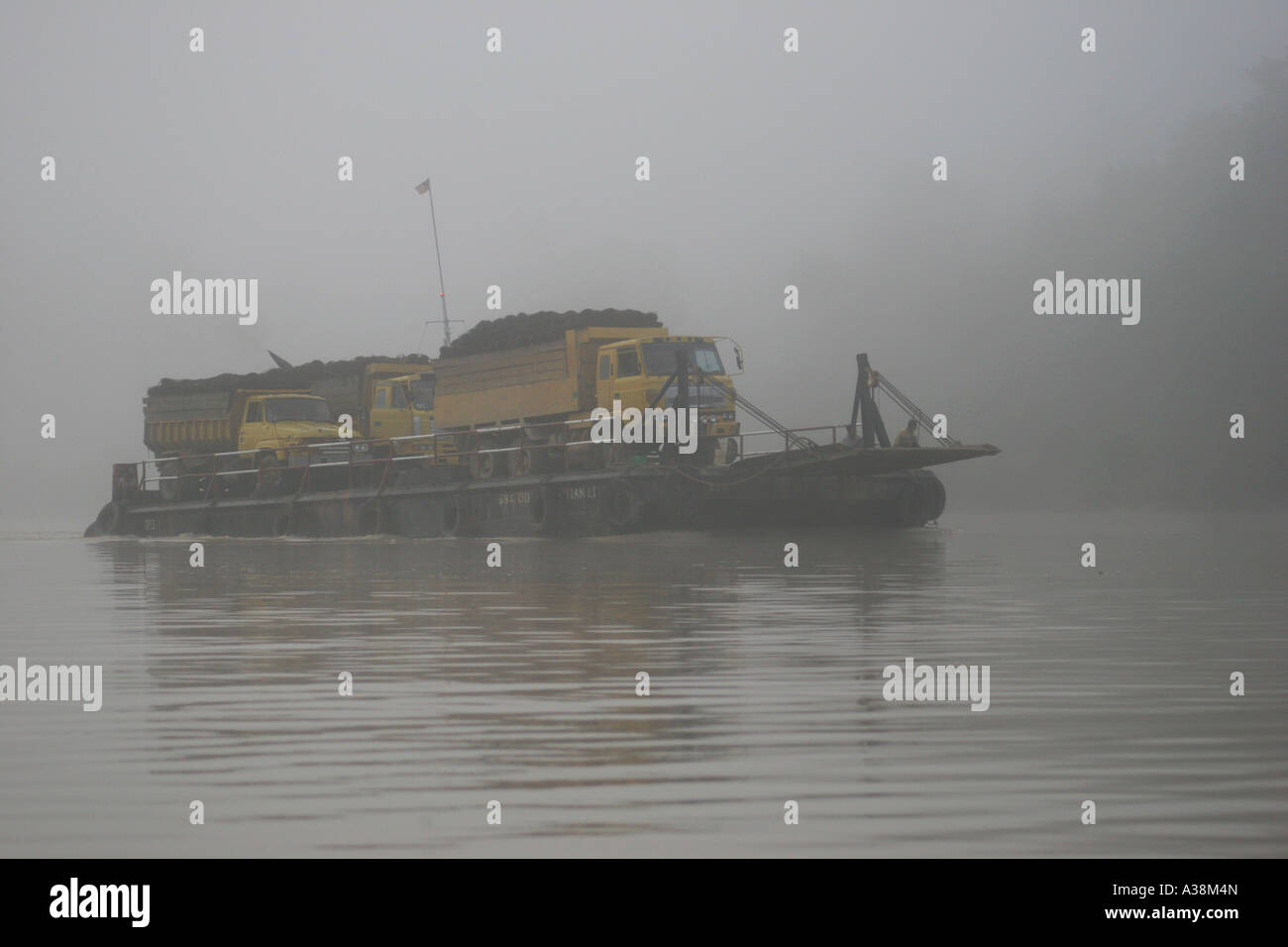 Fruit de l'huile de palme étant transportés en aval avant le lever du soleil sur la rivière Kinabatangan, Sabah, Bornéo, Malaisie Banque D'Images