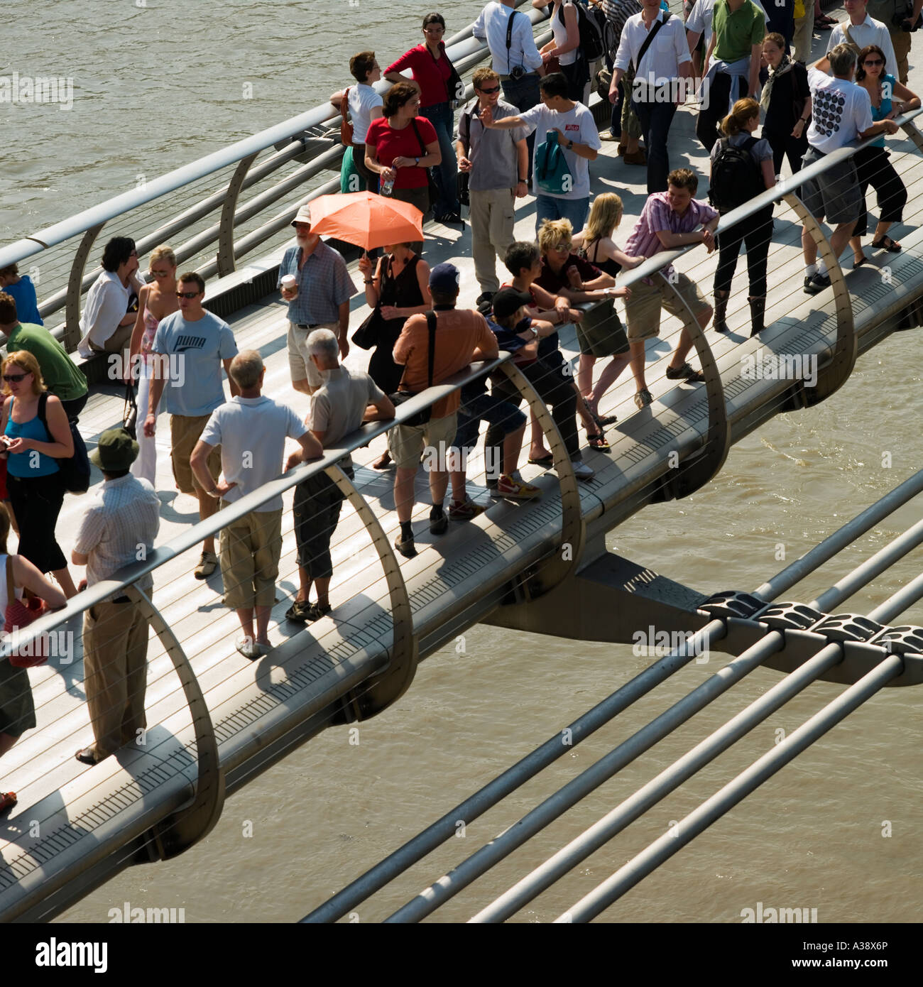 Foule de personnes traversant le pont du millénaire sur la Tamise Londres Angleterre Royaume-uni Banque D'Images