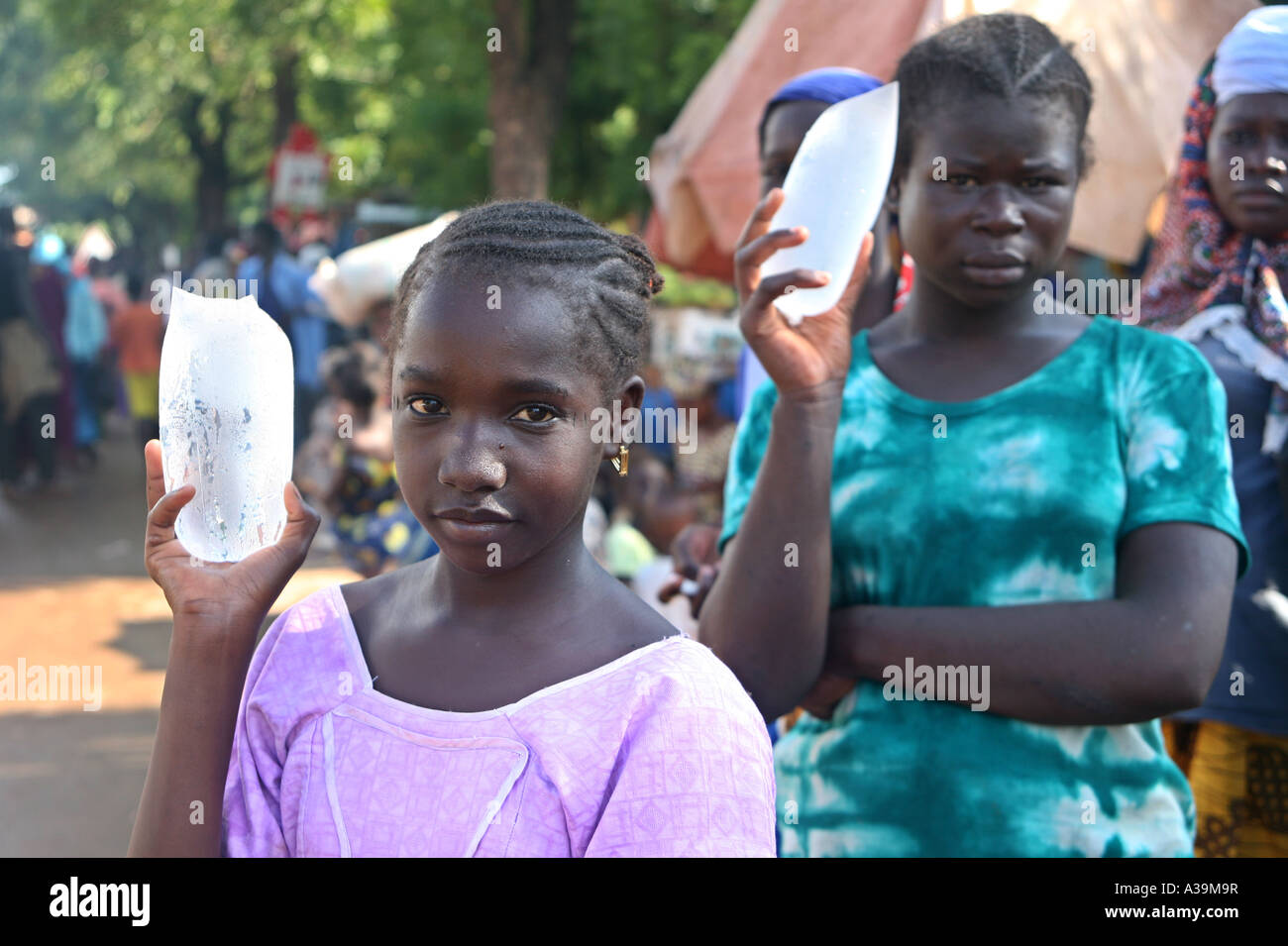 Les jeunes garçons et filles de vendre de l'eau refroidie par le sac sur le côté de la rue de Bamako Mali, Afrique Banque D'Images