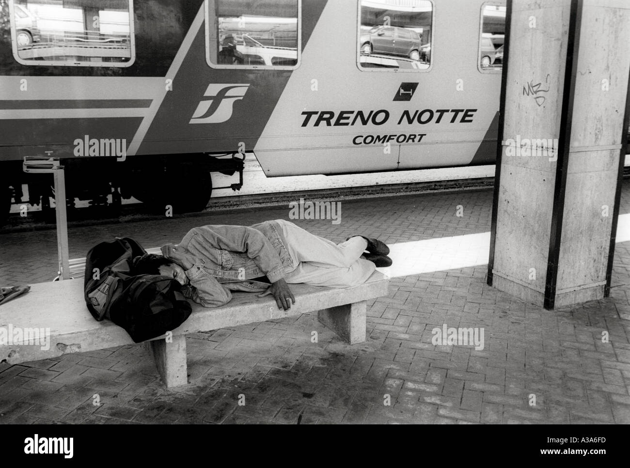 L'homme s'endormir sur un banc à la gare centrale de Palerme Sicile Italie Banque D'Images