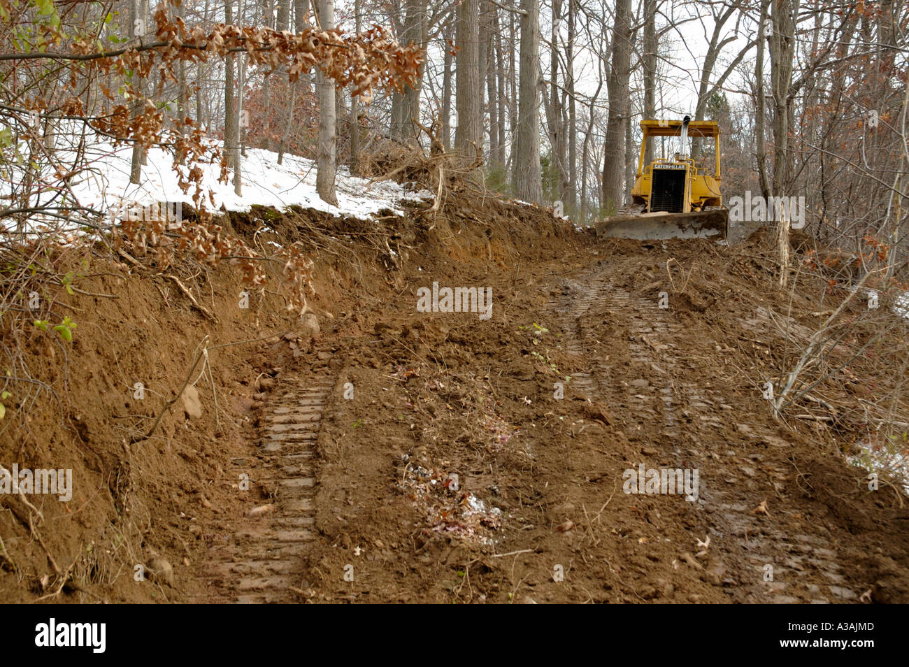 Bulldozer et récemment effacée nouvelle route à travers la déforestation des forêts l'horizontale Banque D'Images