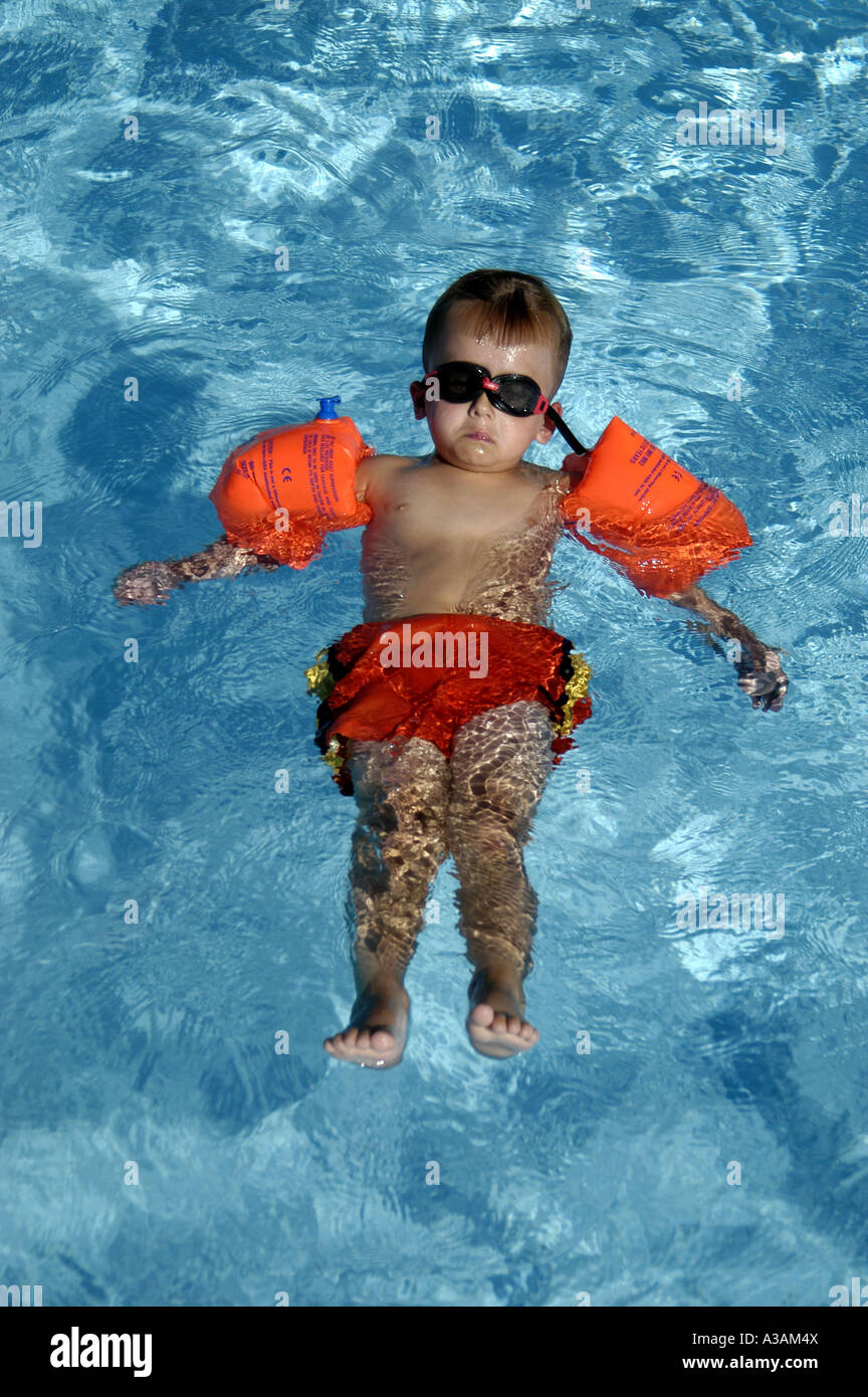 P18 086 4 ans avec de l'eau et des lunettes essayant d'ailes flottent sur le dos Banque D'Images