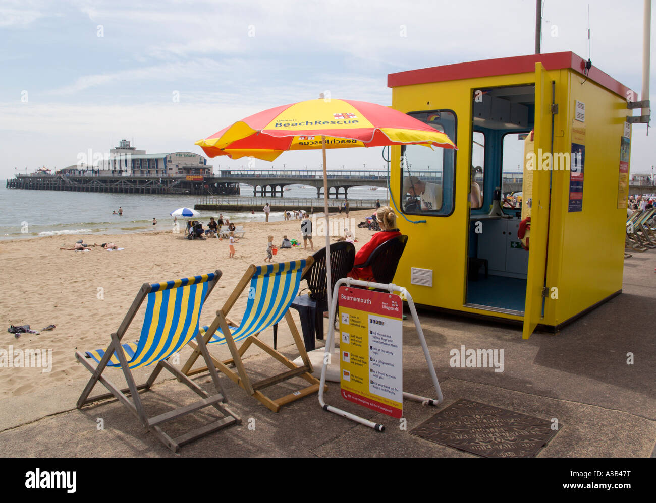 La plage de l'Est de Bournemouth Dorset ANGLETERRE Touristes bronzer sur le sable de la station balnéaire de pier avec lifeguard station et transat. Banque D'Images