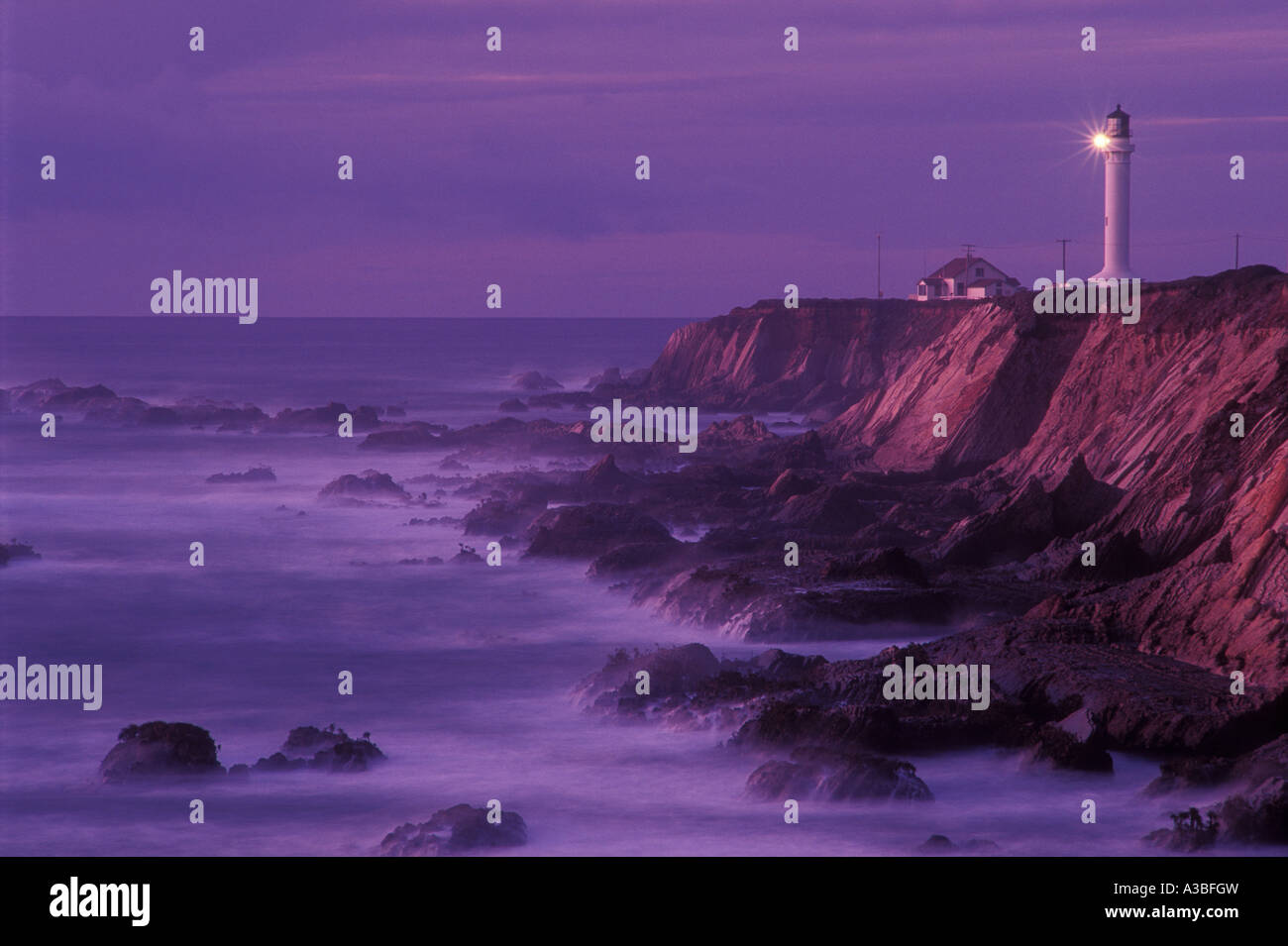 Point Arena Phare sur la côte nord de la Californie au coucher du soleil avec surf sur rocky Shore Cliff Banque D'Images