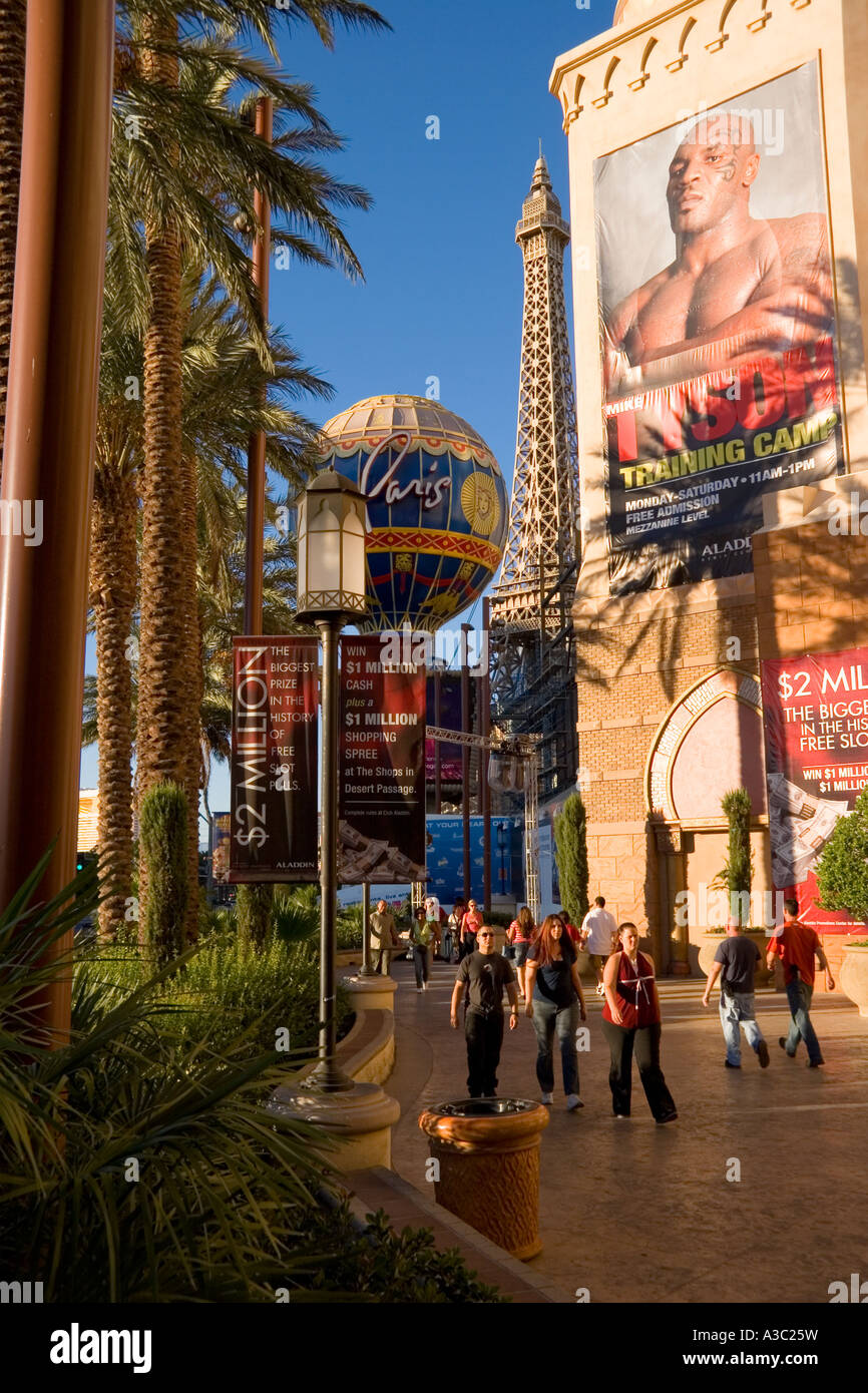 Les touristes déambulant dans les rues de la Bande de Las Vegas sous les palmiers les Paris Casino et un géant de l'affiche de la boxe Banque D'Images