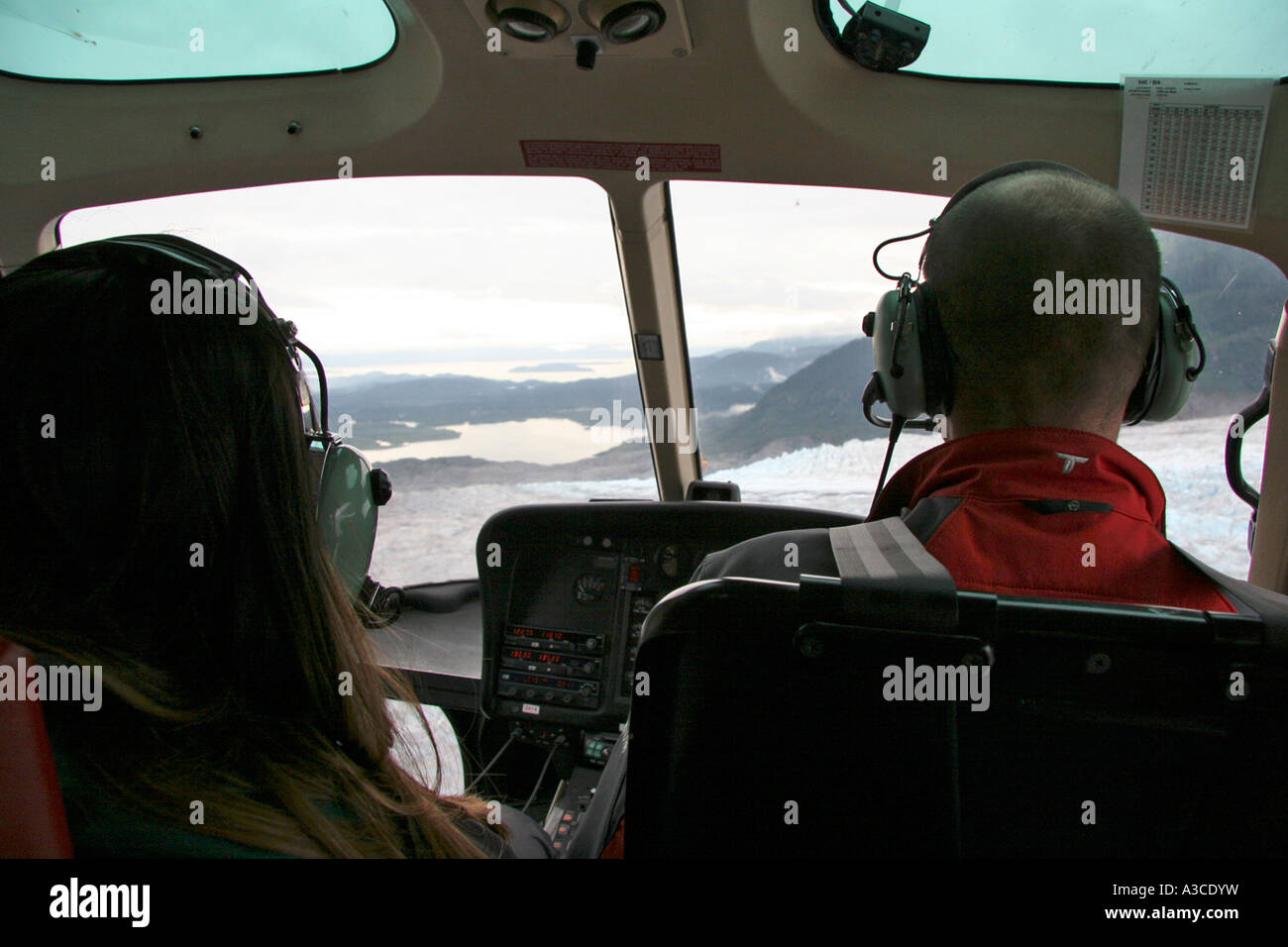 Deux personnes volant en hélicoptère au-dessus de l'Alaska Glacier Banque D'Images