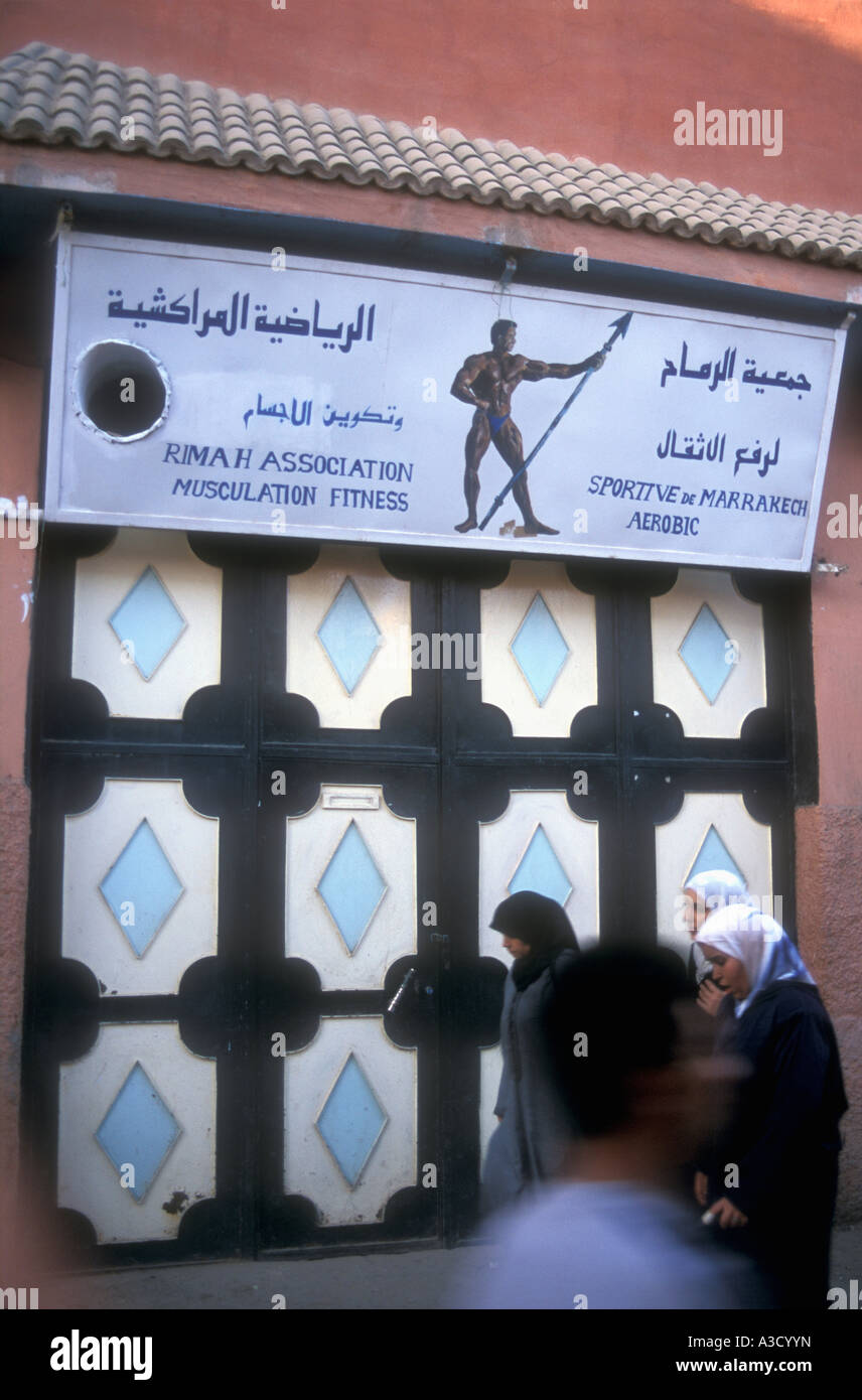 Muslim ladies en costume traditionnel devant l'entrée d'un club de remise en forme ou un gymnase à Marrakech Maroc Banque D'Images