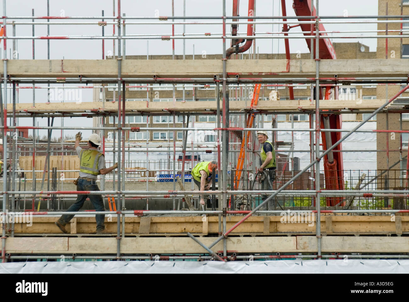 Les échafaudages sur chantier de construction nouveau bloc d'appartements  avec des hommes au travail sur la sécurité d'accès échafaudage wearing hard  hats & high viz vis vest UK Photo Stock - Alamy