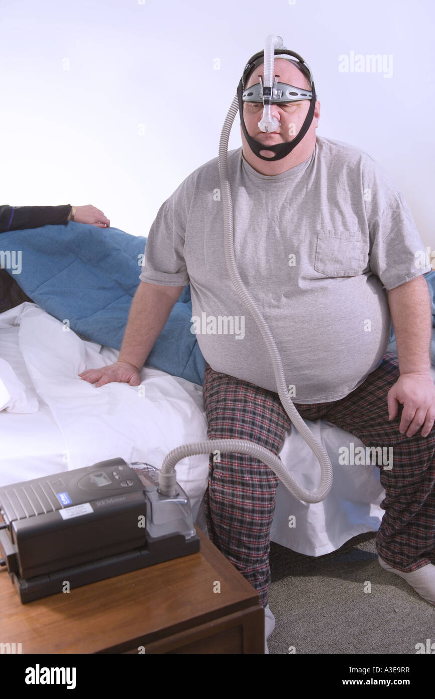 Homme portant un excès de Pression Positive Continue PPC appareil pour aider à respirer et dormir Banque D'Images