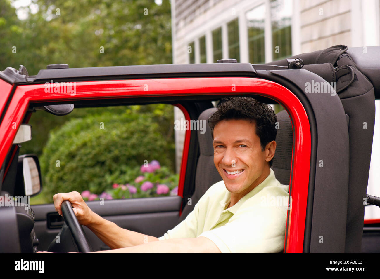 Portrait d'un homme mûr assis dans un véhicule utilitaire sport et souriant Banque D'Images