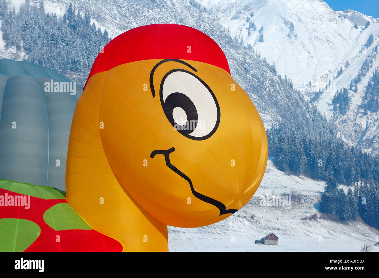 La tête d'une tortue (tortue) ou être un ballon gonflé au Chateau d'Oex montgolfières, Alpes enneigées en arrière-plan Banque D'Images