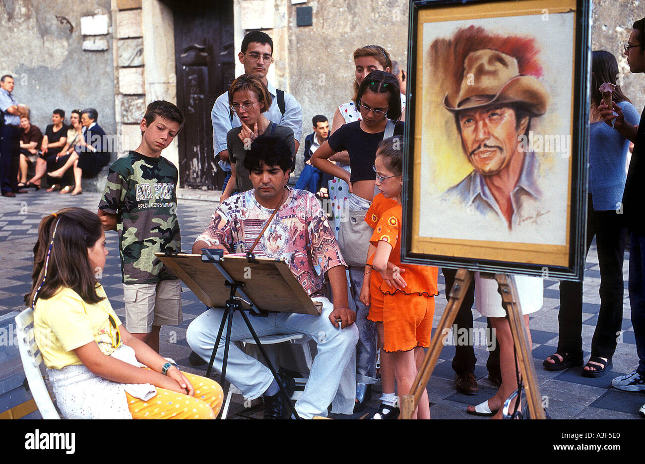 Artiste de rue, peinture les passants à Taormina, Sicile, Italie Banque D'Images